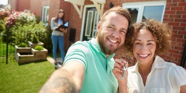 First home buyers in front of their new house